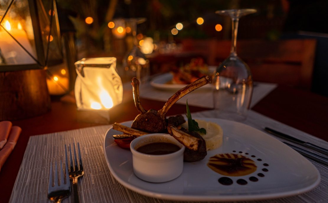 Elegant rack of lamb with puréed potatoes and a rich jus, served under intimate candlelight at a Story Seychelles