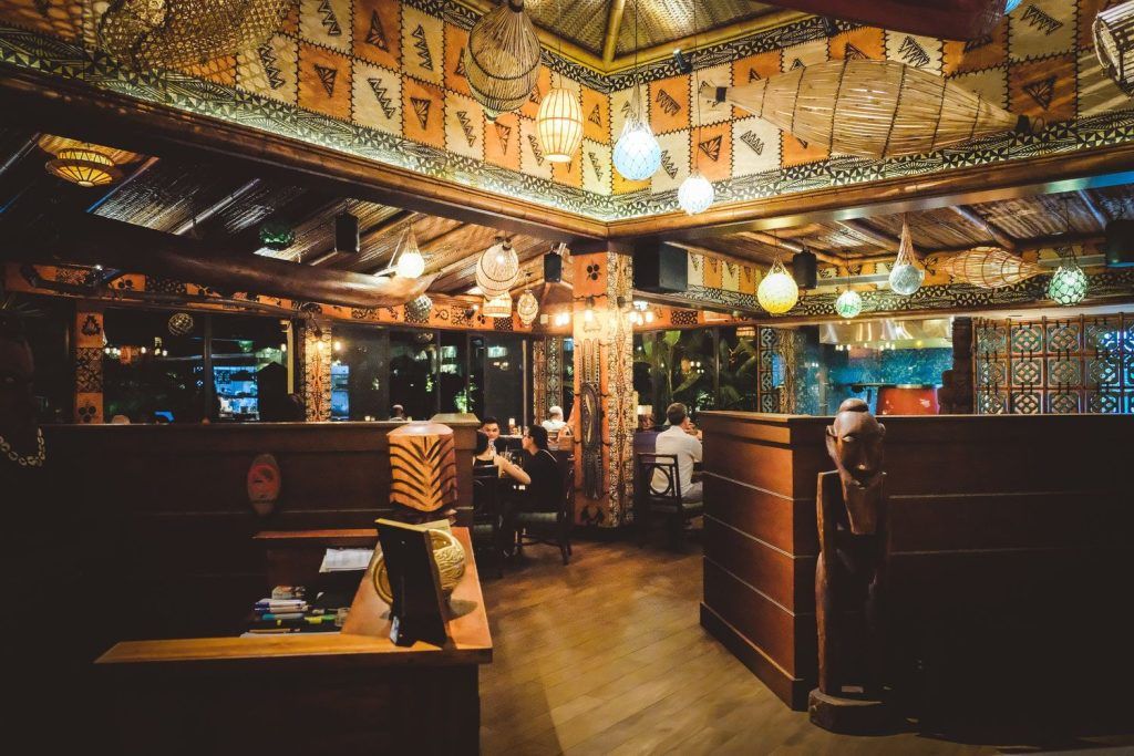 Interior of Trader Vic's showcasing its unique Polynesian-themed decor and ambient lighting with patrons enjoying their evening.