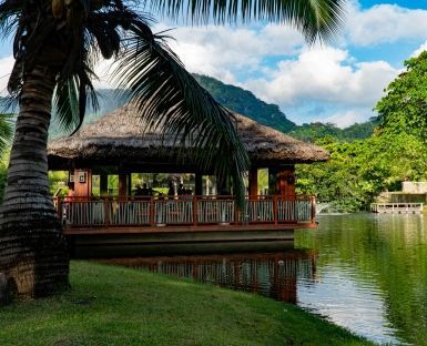 Tranquil riverside restaurant with a thatched roof in the Seychelles Islands.