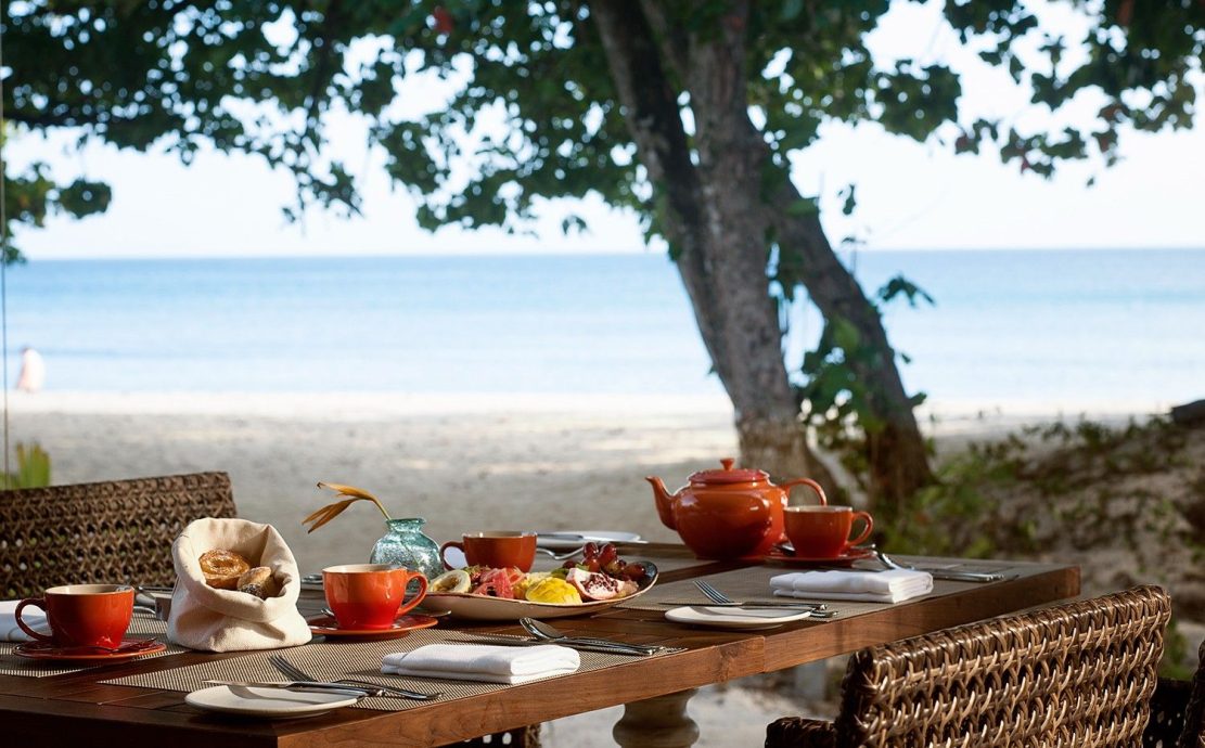A family lunch table with snacks and tea on Beau Vallon Beach in Seychelles.