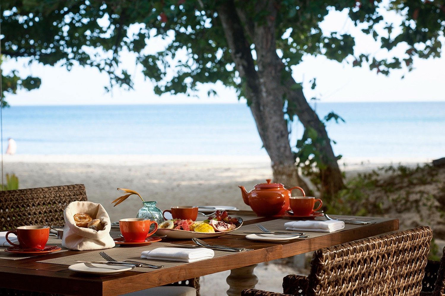 A family lunch table with snacks and tea on Beau Vallon Beach in Seychelles.