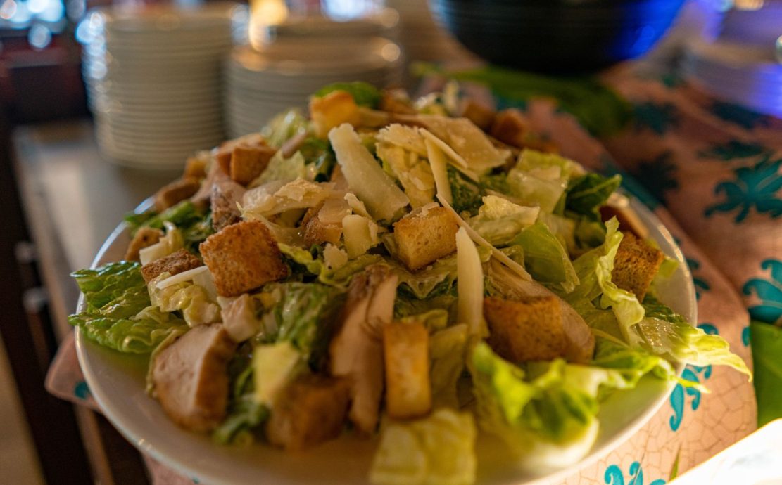 Large Caesar salad with crisp lettuce, croutons, and shavings of parmesan cheese, ready to be served at Vascos Restaurant in Seychelles.