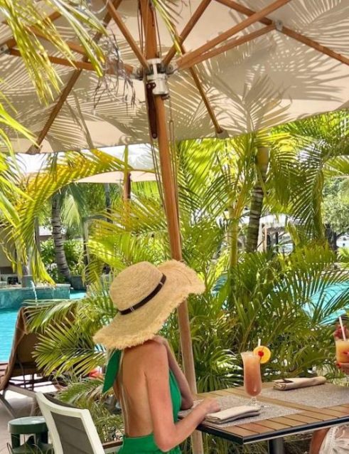 Women enjoying refreshing drinks at a poolside table of the 5 star mahe resort Story Seychelles.