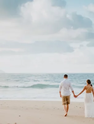 A couple walking along a Seychelles beach.