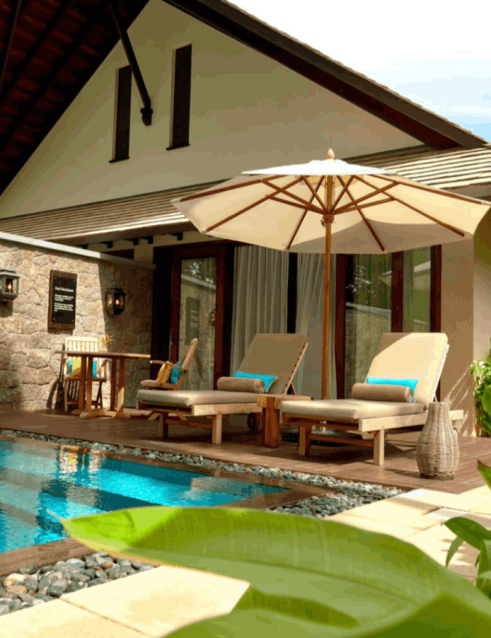 Private pool and patio at a Seychelles resort villa, with mountain views and tropical greenery.