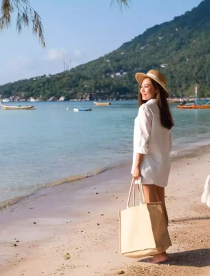 Happy woman visiting the beach after a shopping spree.