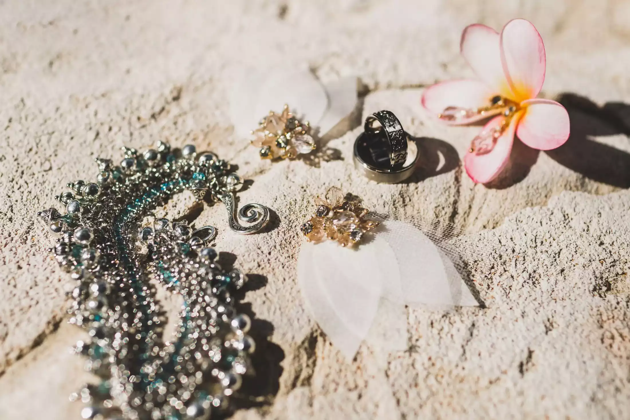 Unique island jewelry on the beach sand.