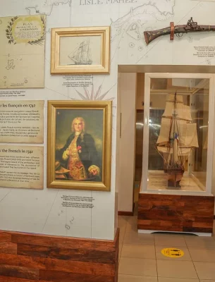 Seychelles National History Museum exhibit displaying historical maps, artifacts, and a model ship related to French exploration.