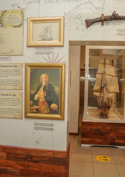 Seychelles National History Museum exhibit displaying historical maps, artifacts, and a model ship related to French exploration.